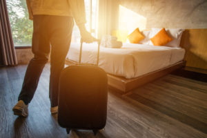 woman pulling her luggage into a hotel room