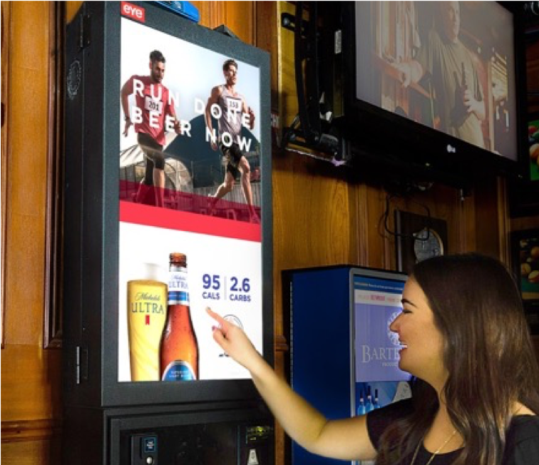 woman interacting with a digital advertisement in a bar